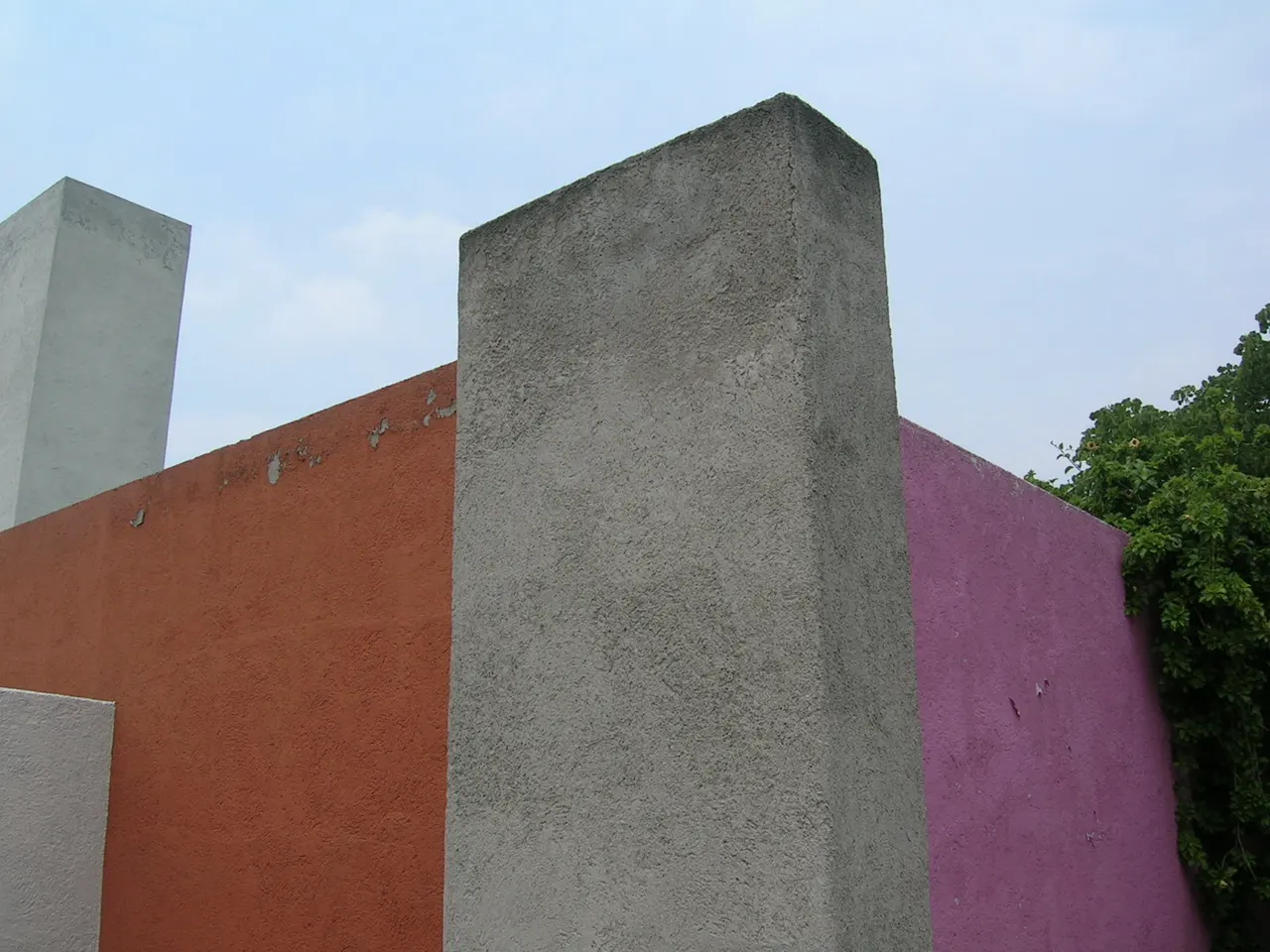 Farbige Wände auf der Dachterrasse von Casa Luis Barragán, mit dem weißen Wasserturm, der sich darüber erhebt